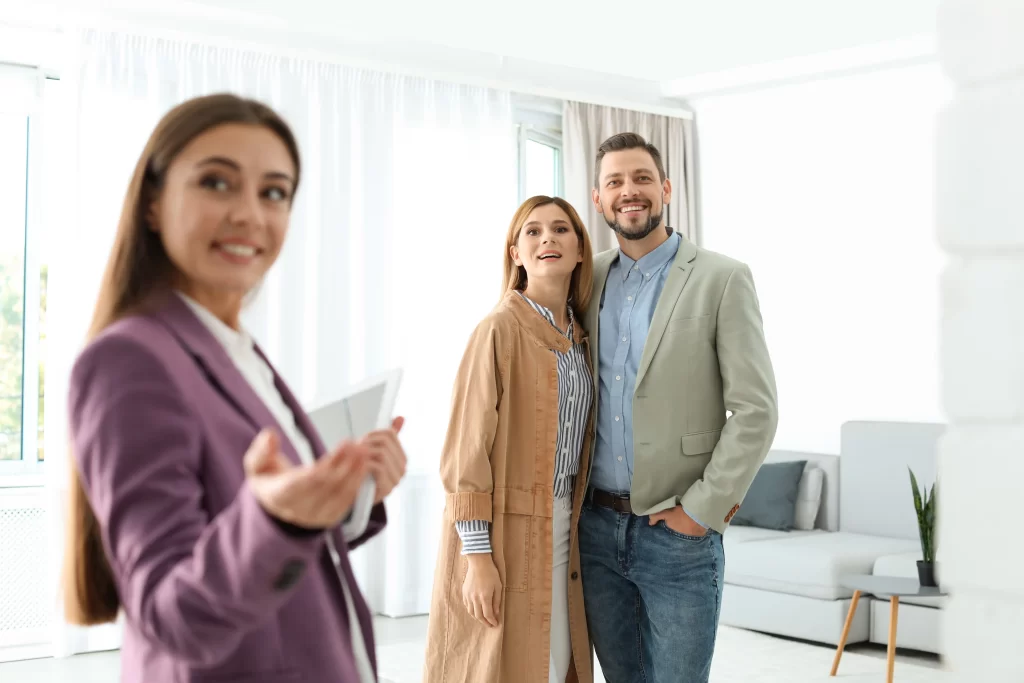 female real estate agent showing new house couple indoors