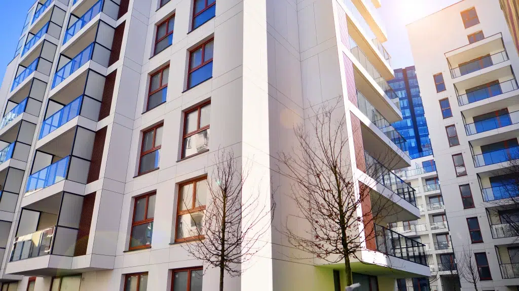 modern apartment building with glass balconies blue sky
